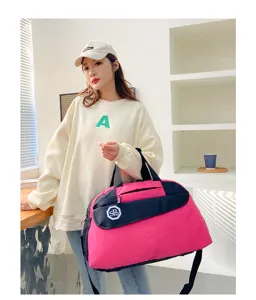 Pink and black travel duffel bag with shoulder strap, convenient folding storage bag.