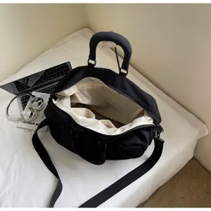 Black travel duffel bag interior detail, featuring spacious compartment and light lining.