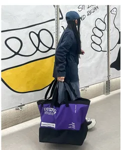 Vue détaillée d'un grand sac de voyage violet et noir, équipement de voyage robuste.