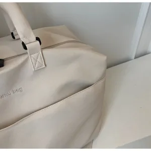 Sac de voyage en toile beige detail, sac de rangement pliable et portable pour voyage.