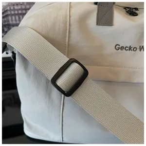 Close-up detail of travel duffel bag adjustable shoulder strap and durable fabric texture.