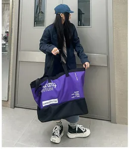 Grand sac de voyage violet et noir, sac a bandouliere en tissu durable pour le sport.