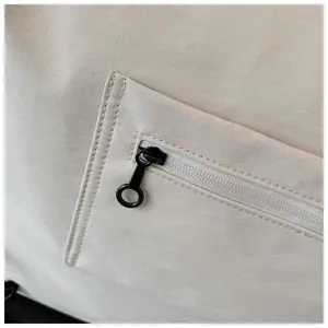 Close-up detail of travel bag featuring zipper pocket, black ring pull and durable fabric.