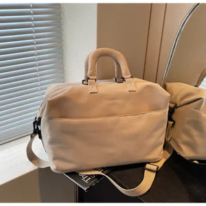 Grand sac de voyage beige avec bandoulière, idéal pour les courts séjours et le rangement quotidien.