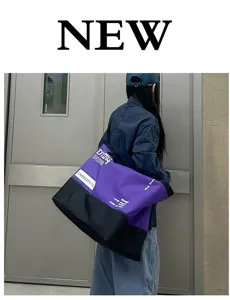 Grand sac de voyage polochon violet et noir, idéal pour les courts trajets et le fitness.