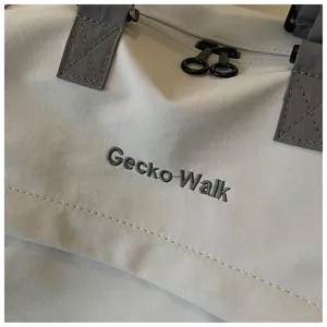 Detailed view of casual travel duffel bag with durable fabric, sturdy handles and stylish embroidery.