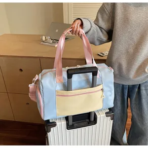 Blue pink colorblock travel duffel bag with trolley sleeve and shoulder strap for short trips.