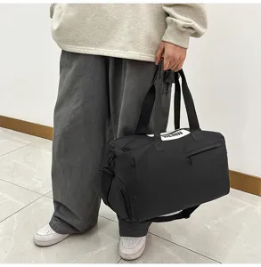 Black waterproof sports fitness duffel bag, large capacity travel luggage storage bag detail.