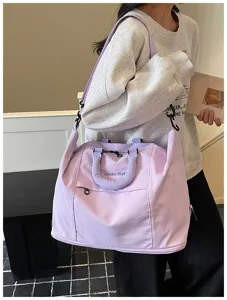 Detailed view of the stylish lavender travel shoulder bag showcasing practical handle design.
