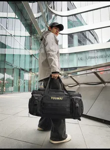 Detail view of large capacity black travel duffel bag with multi pockets and durable straps.