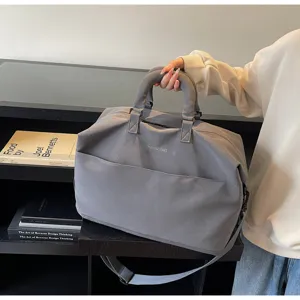 Vue détaillée du sac de voyage gris, grand sac bandoulière pour le sport et les déplacements.