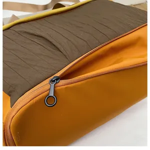 Gedetailleerde close-up van stijlvolle color-block reistas met ritssluiting en textuur.