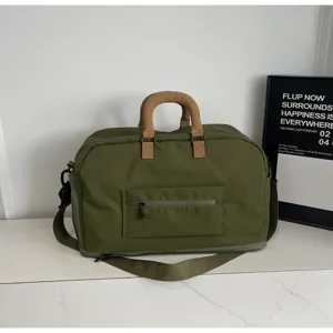Detailansicht der großen grünen Reisetasche mit komfortablen braunen Griffen für Reisen.