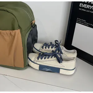 Detailansicht der großen Reise-Duffelbag mit Canvas-Schuhen und stilvollem Poster.