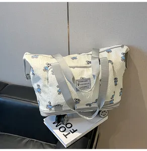 Gedetailleerd overzicht van grote reistas op wieltjes met schattige berenprint en wielen.