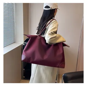 Large capacity travel duffel bag in burgundy nylon, ideal for short trips and gym use.