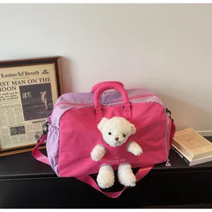 Sac de voyage rose et violet avec un joli détail d'ours en peluche pour les courts trajets.