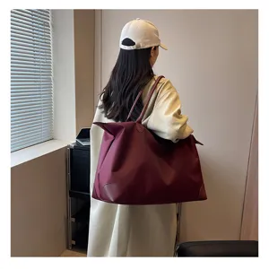 Large capacity burgundy nylon travel tote bag with leather accents for weekend getaways.