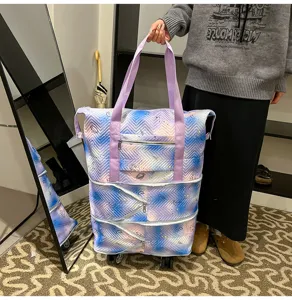 Detail shot of an expandable travel tote bag with wheels and purple gradient pattern.