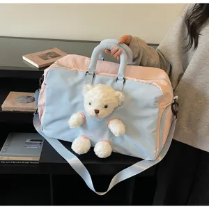 Grand sac de voyage avec joli pendentif en peluche ours, design élégant en rose et bleu.