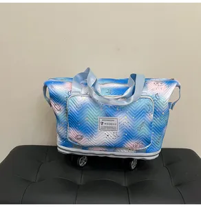 Cosmic print rolling duffel bag detail, expandable travel tote with universal wheels.