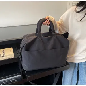 Vue détaillée du sac de voyage gris foncé montrant une grande capacité et des poignées solides.