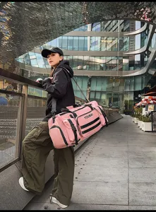 Urban outdoor scene detail showing the multi-pocket pink travel duffel bag in daily use.