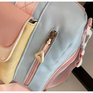 Close-up detail of a colorful pastel travel duffel bag, showing zipper and fabric texture.