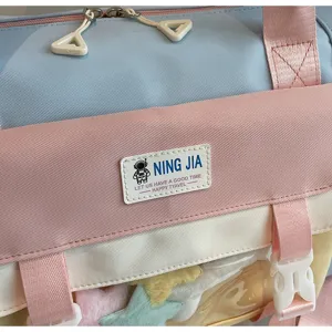 Detail shot of the colorful pastel travel duffel bag showing clear window and badge.