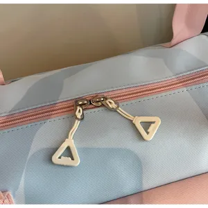 Close-up detail view of the stylish blue and pink travel duffel bag zipper and pull tabs.