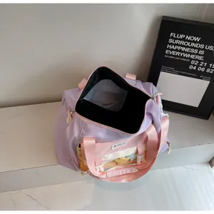 Detail shot of the pastel purple and pink color block travel bag, featuring a clear front pocket.