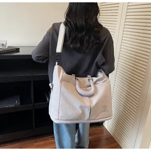 Large capacity solid color travel duffel bag with shoulder strap and dual top handles.
