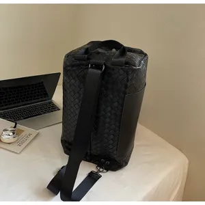 Dettaglio zaino da viaggio intrecciato, pelle nera, design capiente per affari e tempo libero.