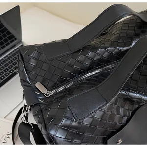 Dettaglio borsa da viaggio in pelle intrecciata nera, grande borsa con stile.