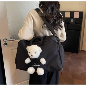 Vue détaillée du grand sac de voyage avec adorable peluche d'ours pour femmes et déplacements.