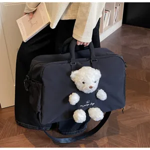 Sac de voyage noir avec détail d'ours en peluche, idéal pour le sport et les courts séjours.