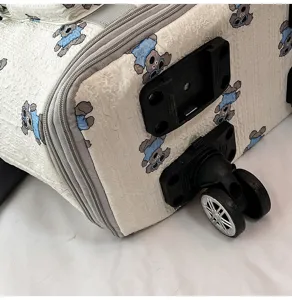 Reisbagage detail wiel en cartoon hond patroon stof textuur close up aanzicht