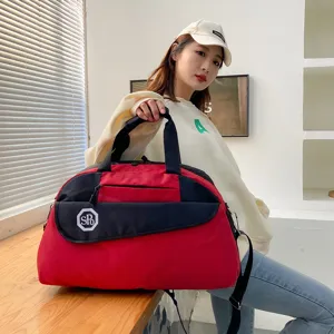 Detailed view of the red and black travel duffel bag, featuring spacious storage for travel and gym.