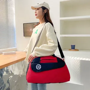 Detail view of the red and black travel duffel bag showing durable fabric and front pocket.
