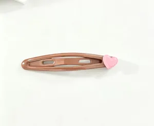Close-up detail of the cute brown snap hair clip featuring a lovely pink heart decoration.