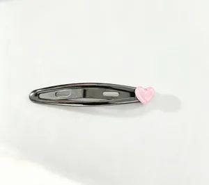 Detailed view of a black metal snap hair clip adorned with a cute pink heart charm for daily wear.