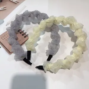 Detail shot of pleated chiffon hair hoop in grey and beige, elegant everyday hair accessory.