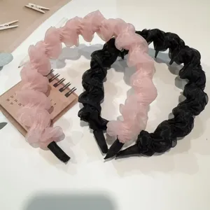 Chiffon ruffled headband detail showing soft pink and black fabric with anti-slip teeth.