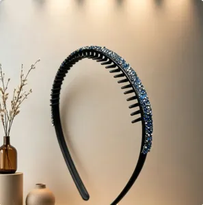 Close-up of black rhinestone headband with teeth anti-slip design, sparkling blue crystals detail.