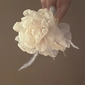 Close-up detail of the elegant mesh flower feather hair claw clip, delicate fabric texture.