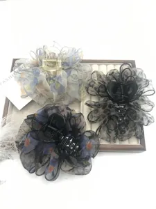 Gedetailleerde close-up van grote organza bloem haarclips met transparant bubbel ontwerp.