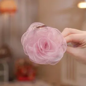 Detailed view of pink organza rose hair claw clip, elegant floral hair accessory for women.