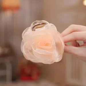 Close-up detail of a delicate mesh rose flower hair claw clip in soft champagne color.