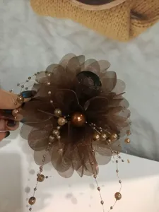 Detailed view of dark brown organza flower hair claw clip with delicate hanging pearl bead strings.