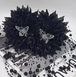 Pince a cheveux fleur en maille noire avec papillons en strass et franges de perles elegantes.